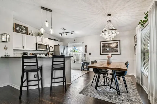 a view of a a dining room with furniture window and wooden floor