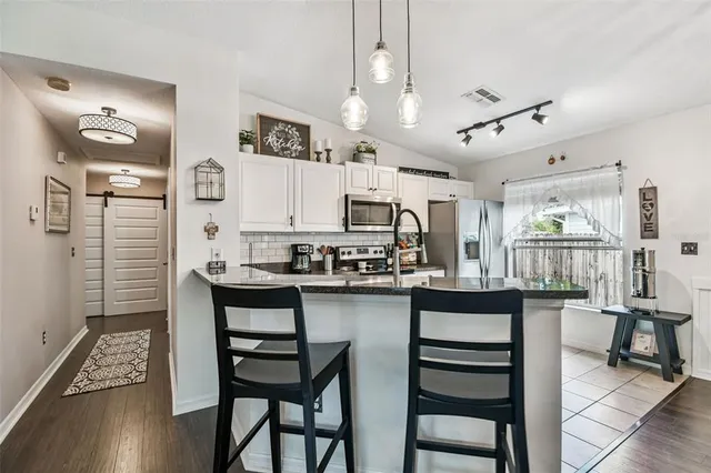 a kitchen with granite countertop counter space dining table and stainless steel appliances