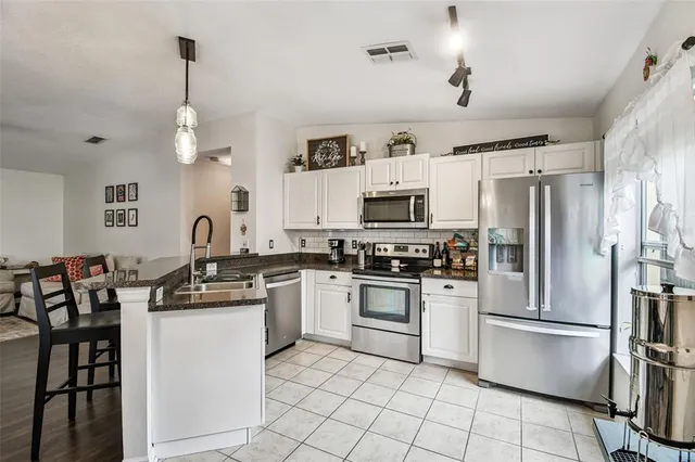 a kitchen with white cabinets and stainless steel appliances