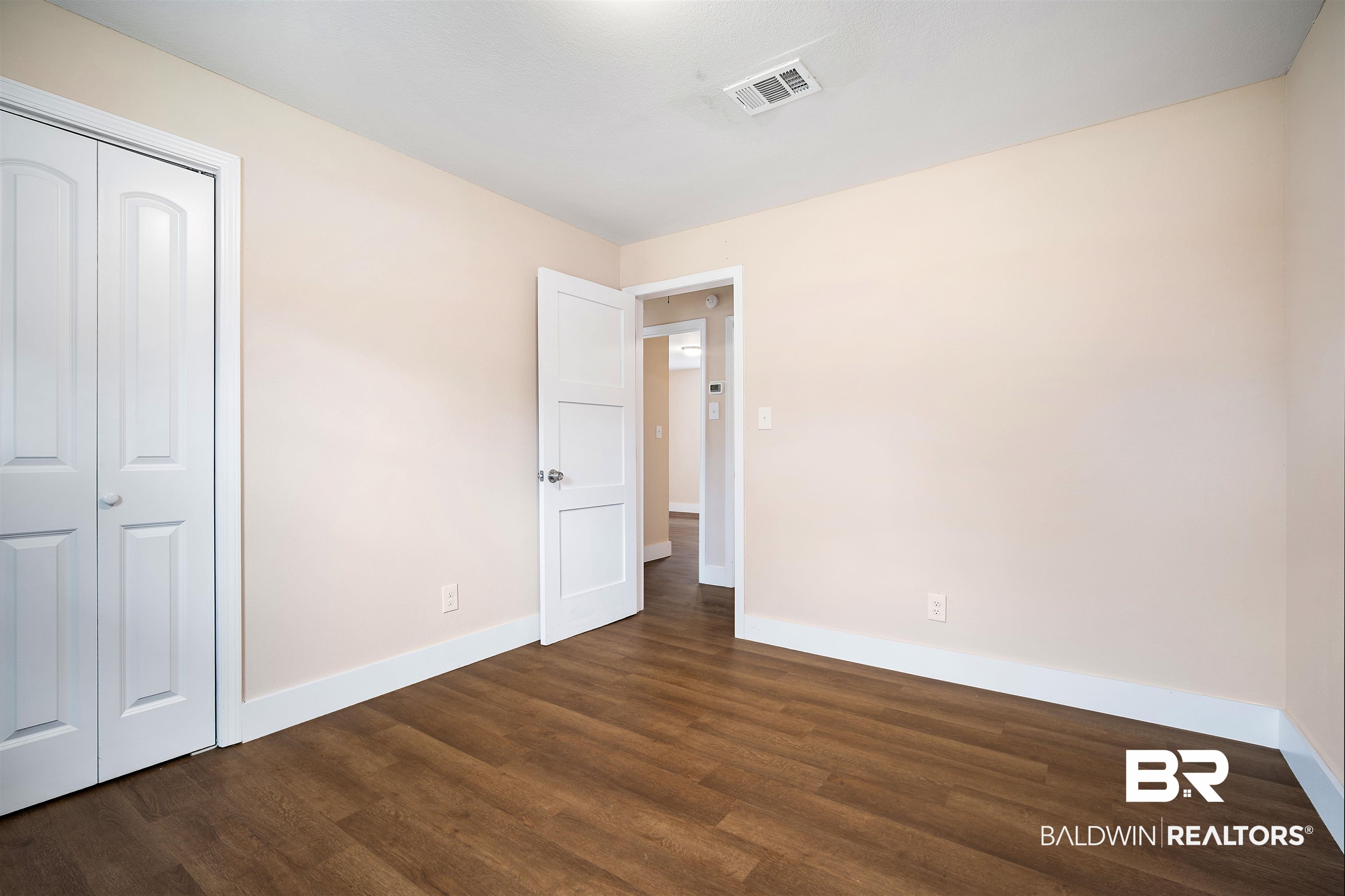 2119 Autrey Avenue Eight Mile, AL 36613 - Photo 18 of 22 Unfurnished bedroom featuring dark hardwood / wood-style floors and a closet