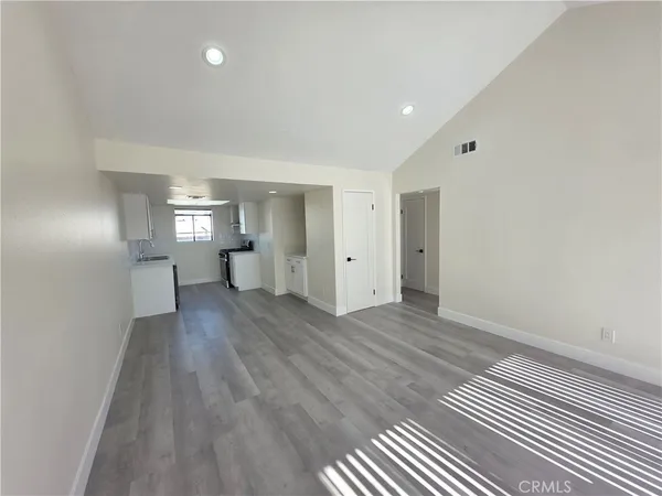 a view of empty room with wooden floor