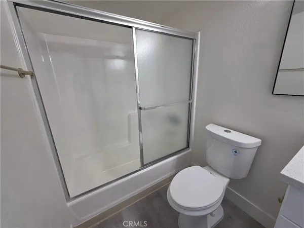a white toilet sitting next to a shower