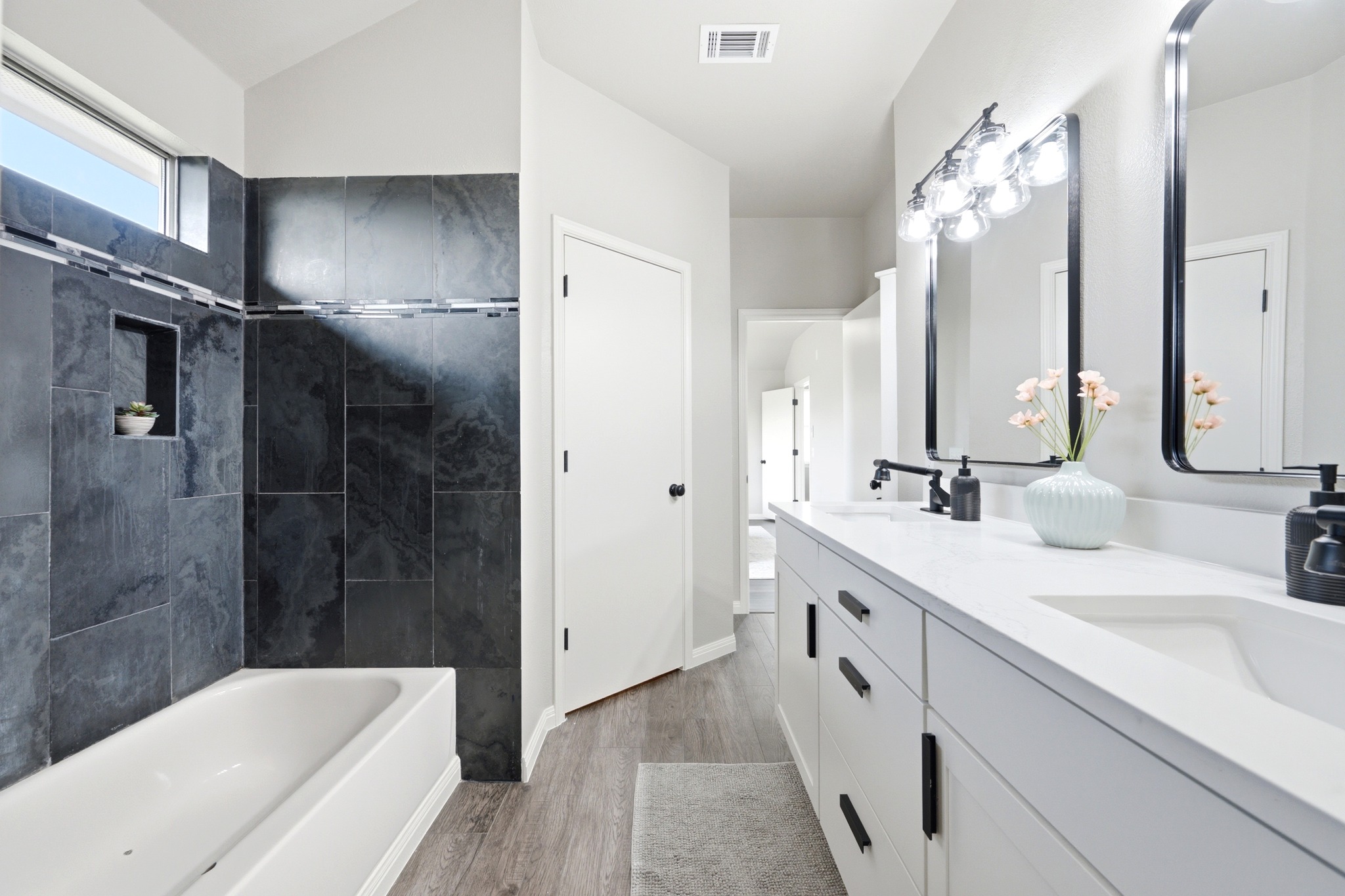 1504 Waterfall Avenue Leander, TX 78641 - Photo 16 of 25 The primary ensuite brings in a quartz dual vanity and a striking tile surround.