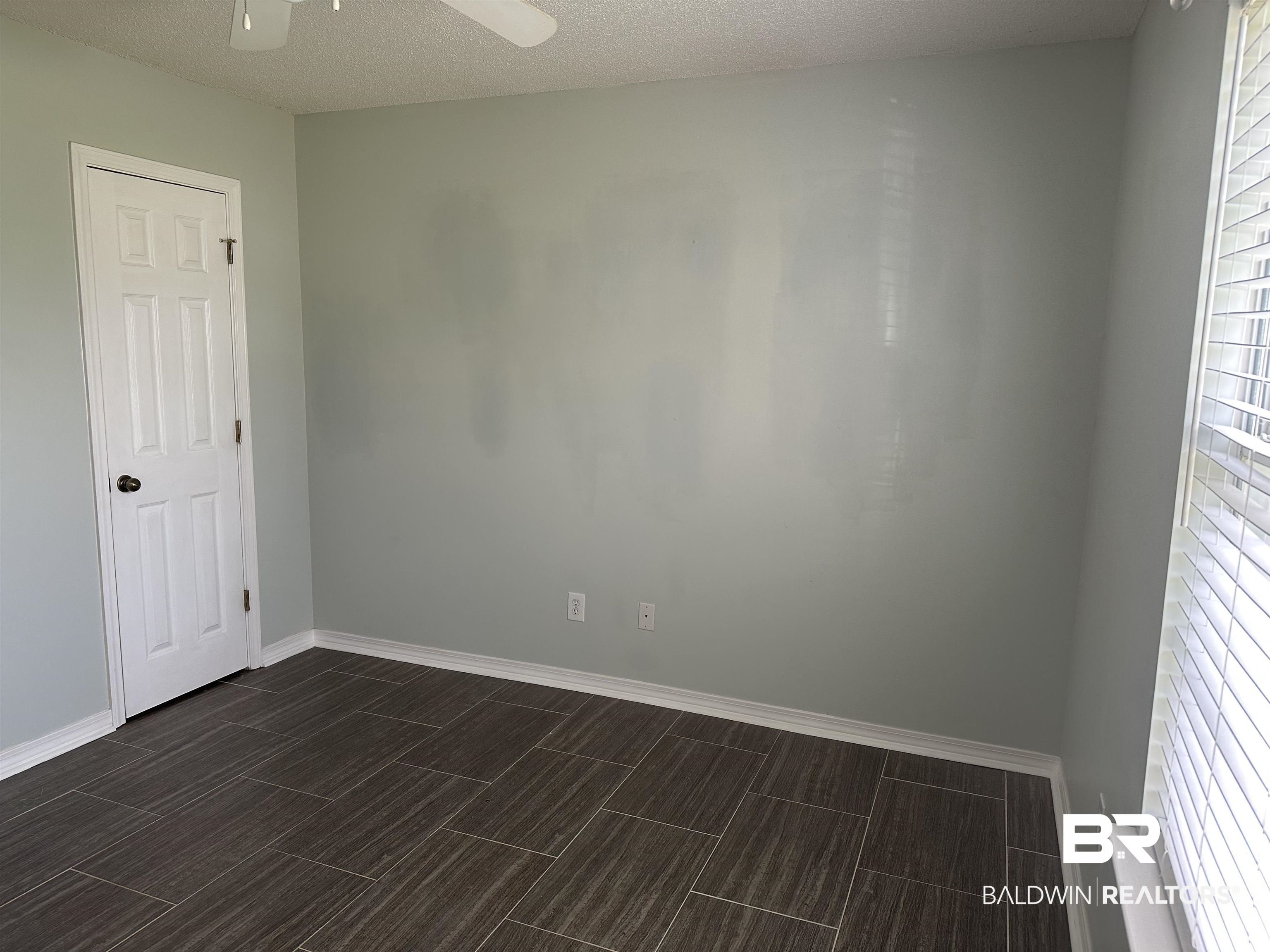 4882 Rebecca Place Mobile, AL 36695 - Photo 18 of 29 Empty room featuring baseboards, a textured ceiling, ceiling fan, and wood tiled floor