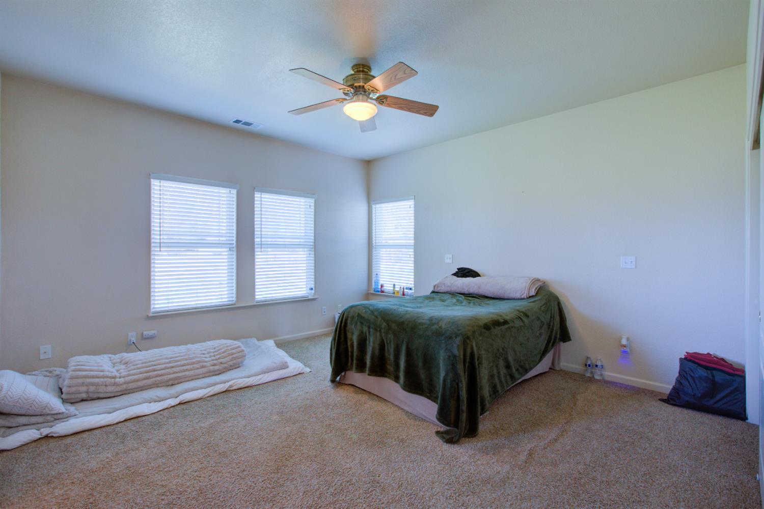 9681 Wamble Road Oakdale, CA 95361 - Photo 18 of 50 a bedroom with a bed and a chandelier