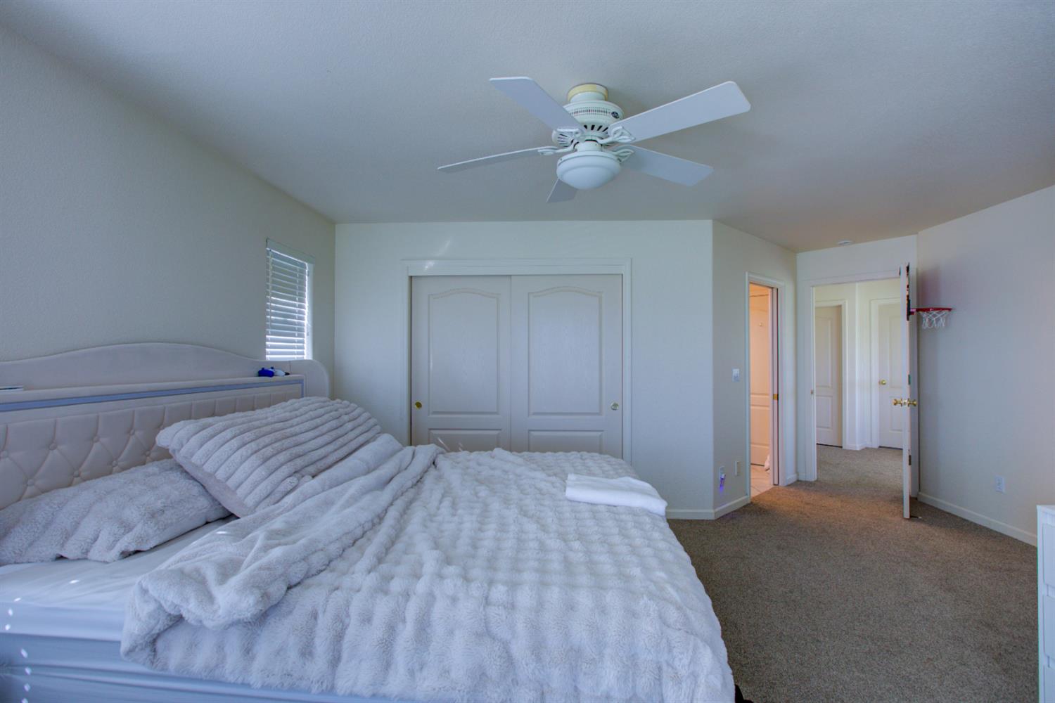 9681 Wamble Road Oakdale, CA 95361 - Photo 19 of 50 a bedroom with a large bed and a chandelier