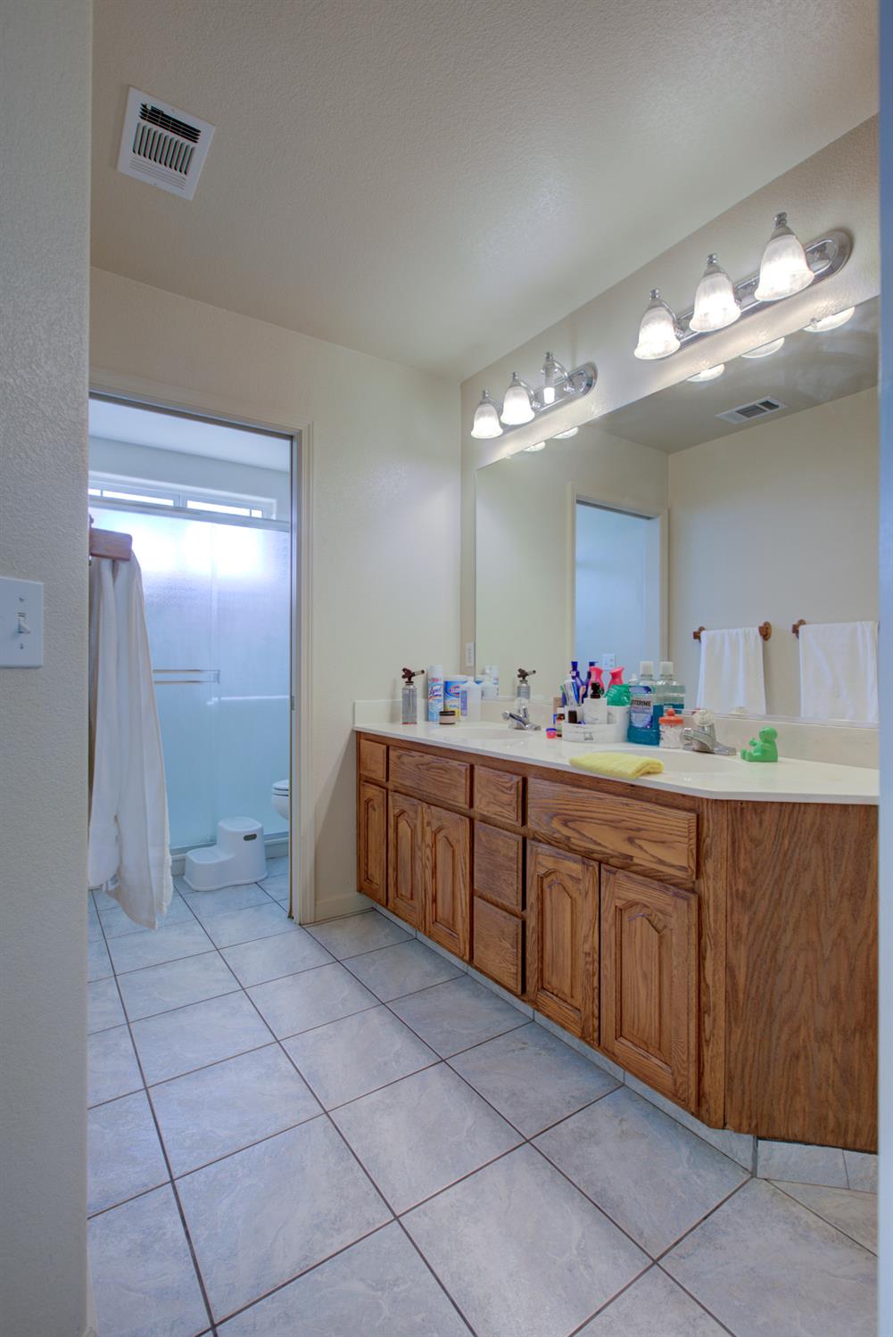 9681 Wamble Road Oakdale, CA 95361 - Photo 36 of 50 a spacious bathroom with a granite countertop sink a mirror and a shower