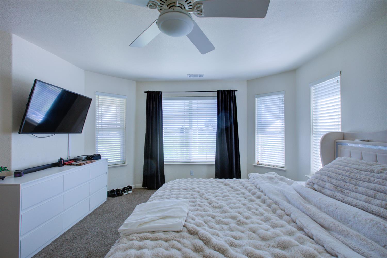 9681 Wamble Road Oakdale, CA 95361 - Photo 43 of 50 a bedroom with a bed and a flat tv screen on wall