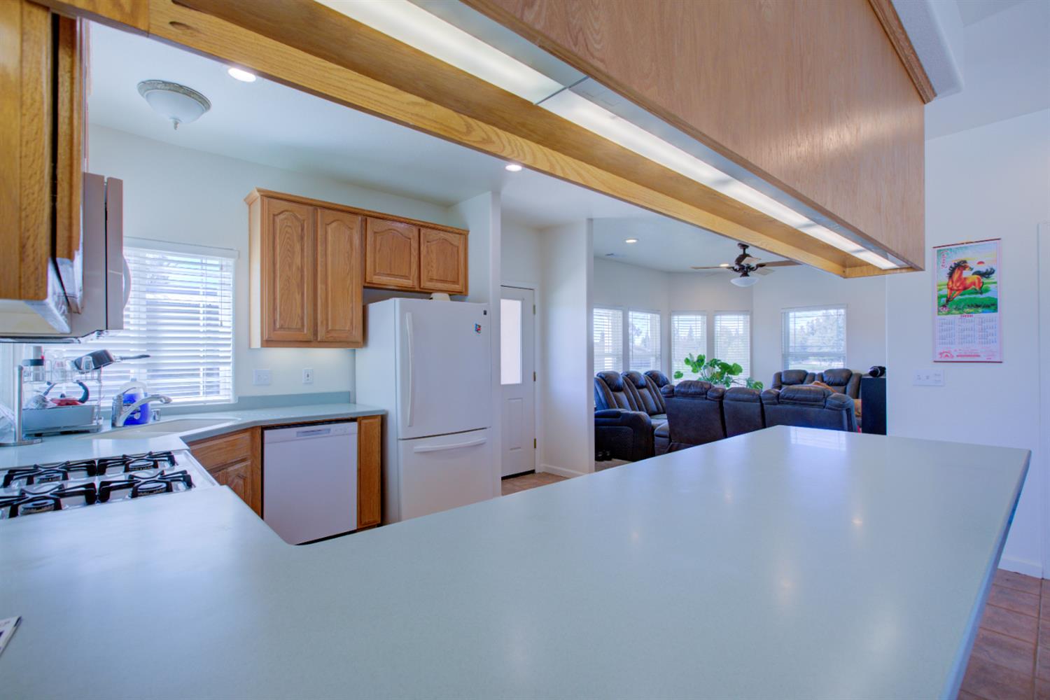 9681 Wamble Road Oakdale, CA 95361 - Photo 8 of 50 a large kitchen with stainless steel appliances a refrigerator a sink dishwasher a dining table and chairs with wooden floor