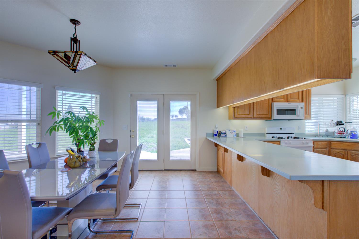 9681 Wamble Road Oakdale, CA 95361 - Photo 9 of 50 a large kitchen with stainless steel appliances a large counter top a stove a chimney a sink and potted plant