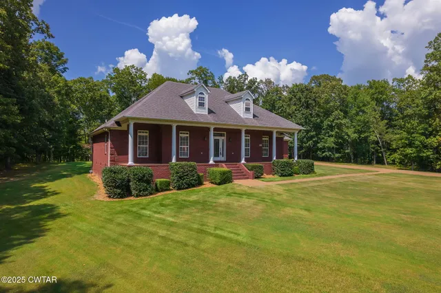 a view of a house with a yard and potted plants