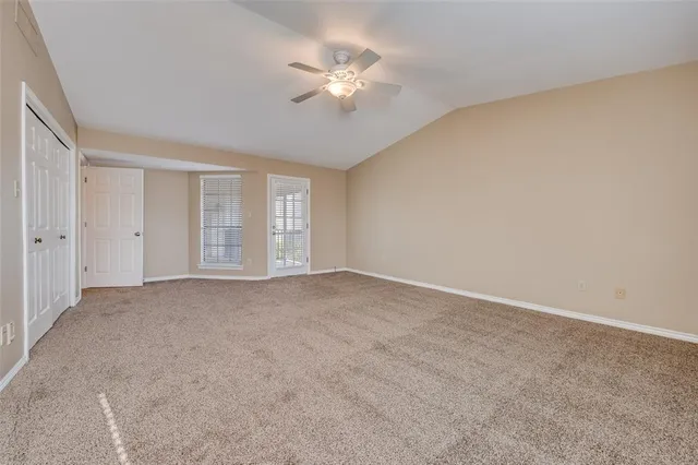 a view of an empty room with a chandelier fan