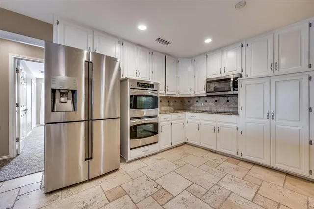a view of a big room with windows and a chandelier fan
