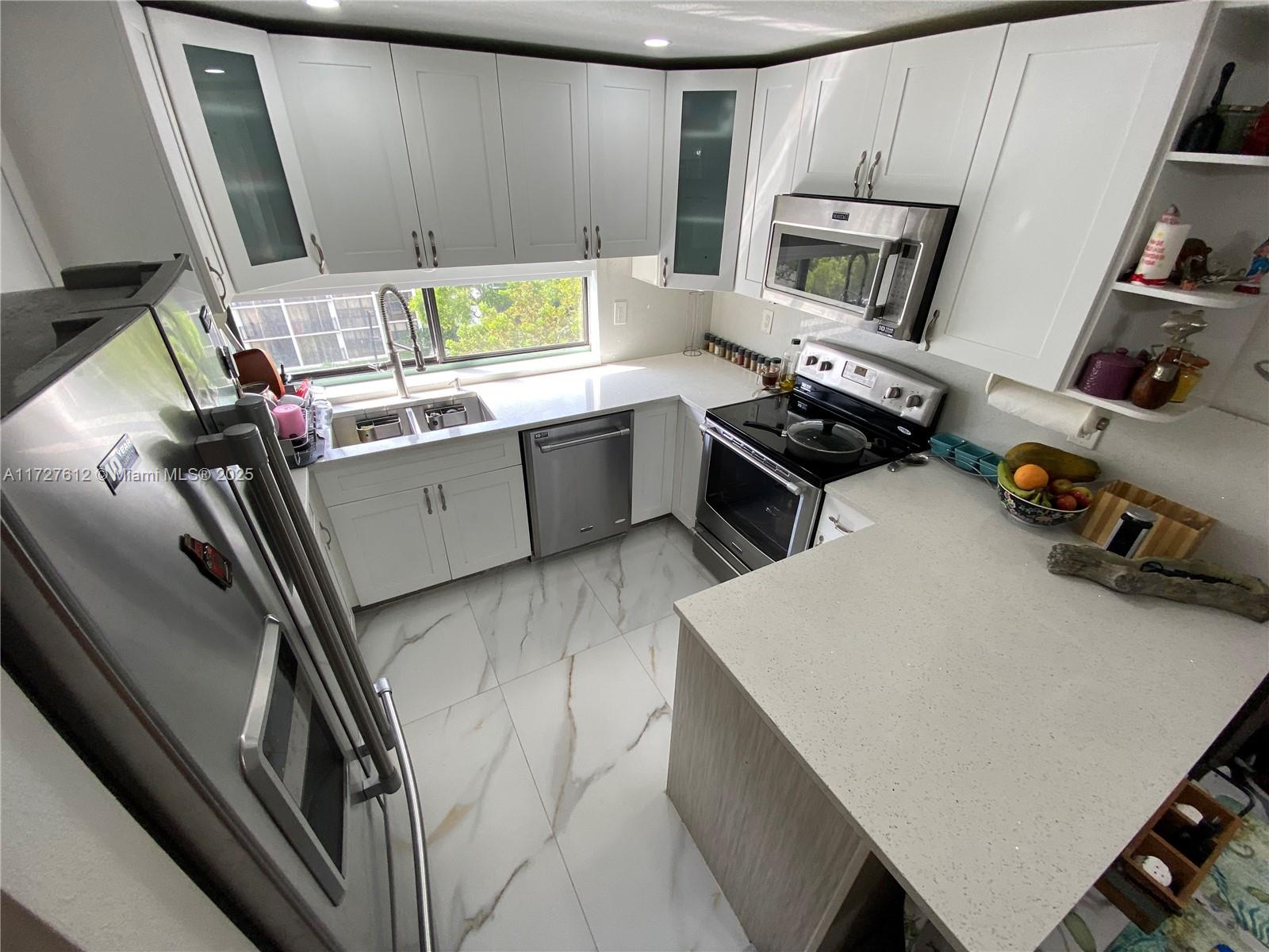 a kitchen with a sink appliances and cabinets