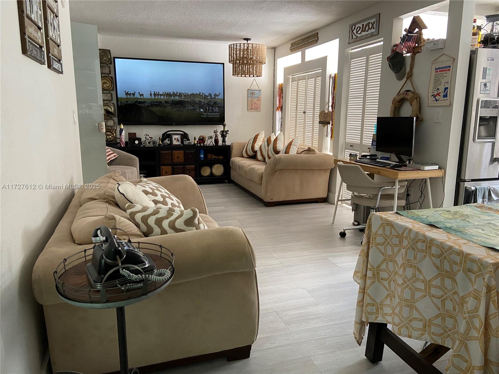 17021 North Bay Road, Unit 627 Sunny Isles Beach, FL 33160 - Photo 12 of 24 a living room with furniture and a flat screen tv