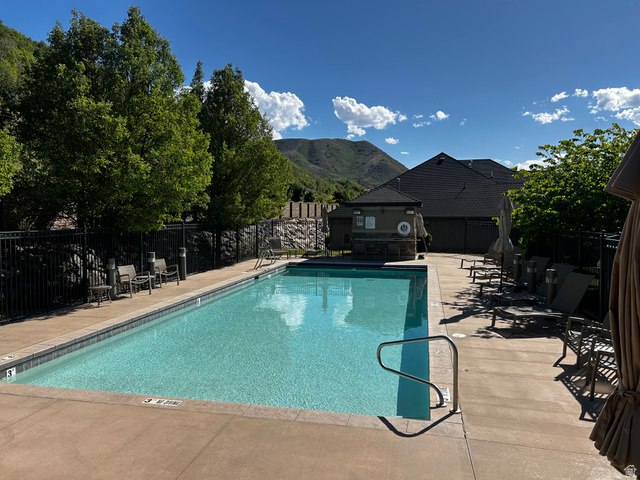 1154 Sunset Dunes Way Draper, UT 84020 - Photo 6 of 50 Outdoor swimming pool with a concrete surround, security fencing, and mountain backdrop
