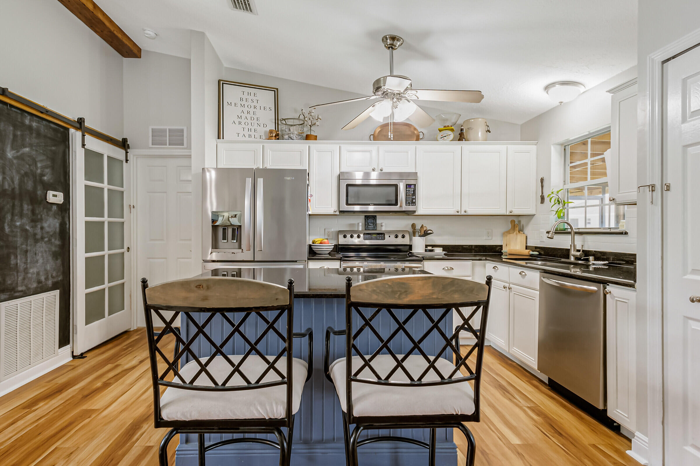 1030 San Rafael Road Southwest Palm Bay, FL 32908 - Photo 14 of 37 a kitchen with a dining table chairs stainless steel appliances and cabinets