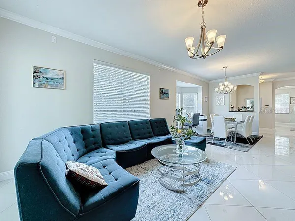 a living room with furniture a dining table and a chandelier