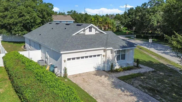 a view of a house with a yard and large tree
