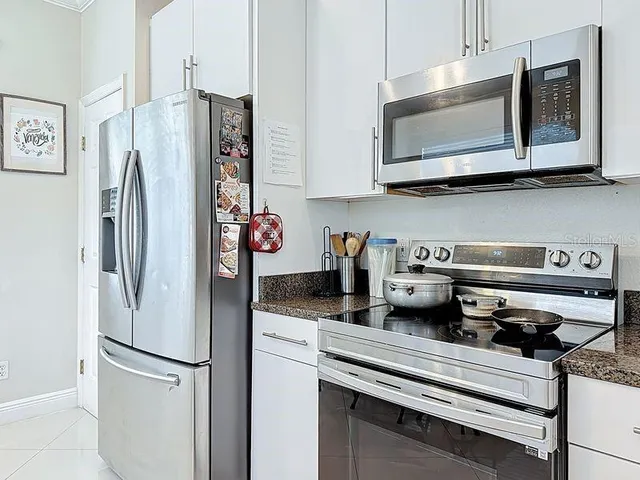 a kitchen with stainless steel appliances granite countertop a refrigerator sink and microwave