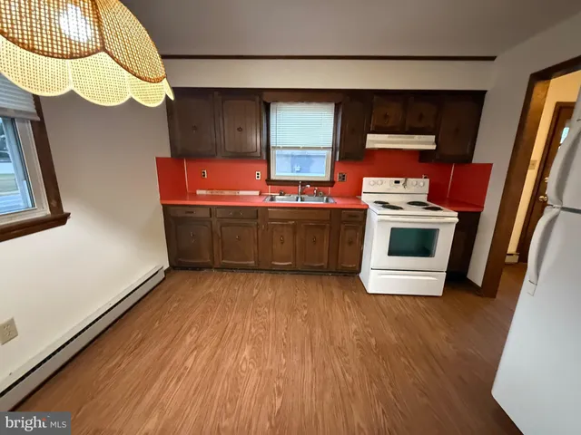 a view of kitchen with wooden floor and electronic appliances