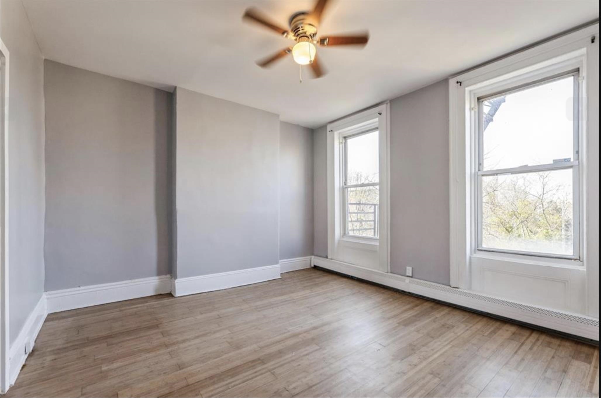 291 Forrest Street, Unit 2 Jersey City, NJ 07304 - Photo 2 of 17 an empty room with wooden floor chandelier fan and windows