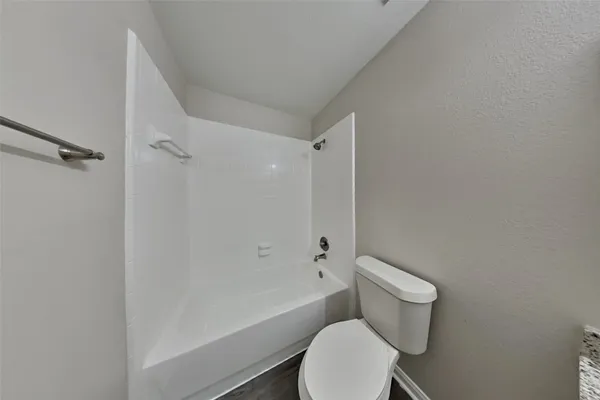 a white toilet and tub sitting next to a bathroom sink