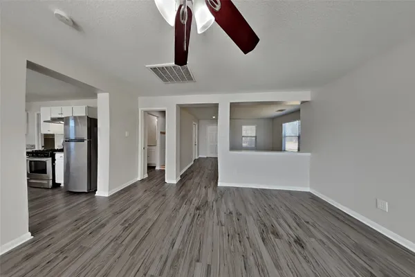 a view of empty room with wooden floor