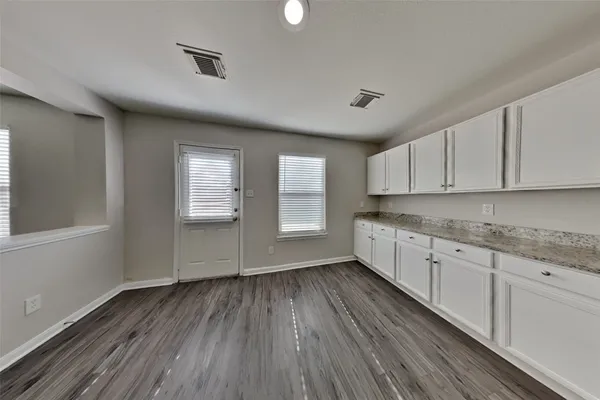 a kitchen with granite countertop wooden floors a sink and a window
