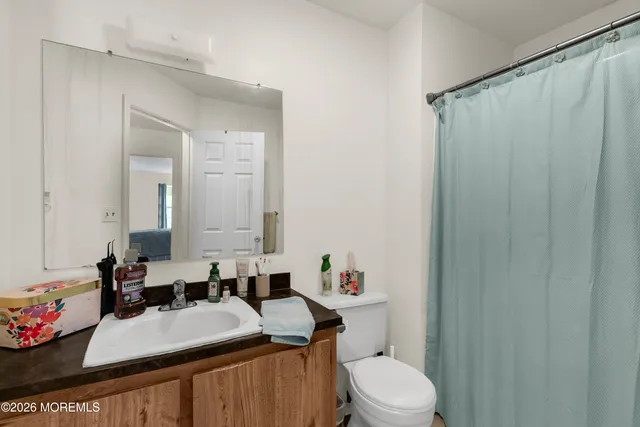 a bathroom with a sink a toilet and shower curtain