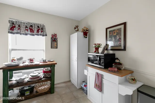 a room with a baby bed toys and paintings on the wall