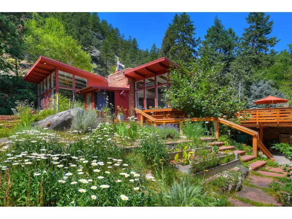 a backyard of a house with a garden and outdoor seating