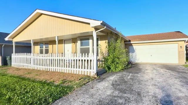 a view of a house with a yard and fence