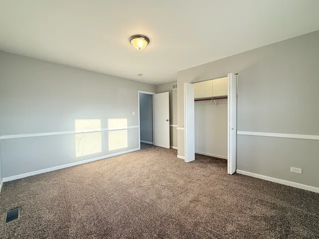 an empty room with windows and closet