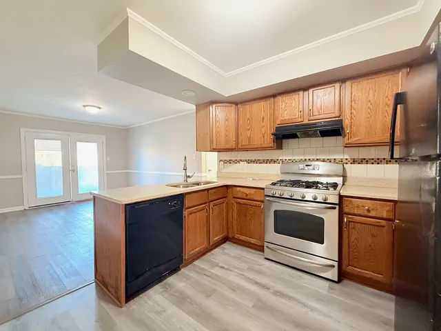 a kitchen with stainless steel appliances granite countertop a stove a sink and a microwave