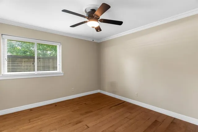 a view of a big room with wooden floor and windows