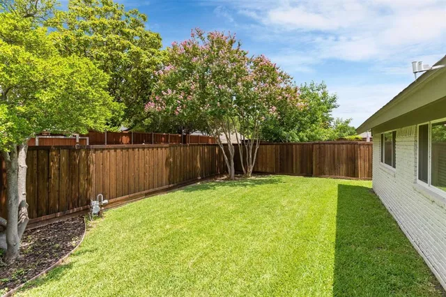 a view of a backyard with a small cabin and wooden fence