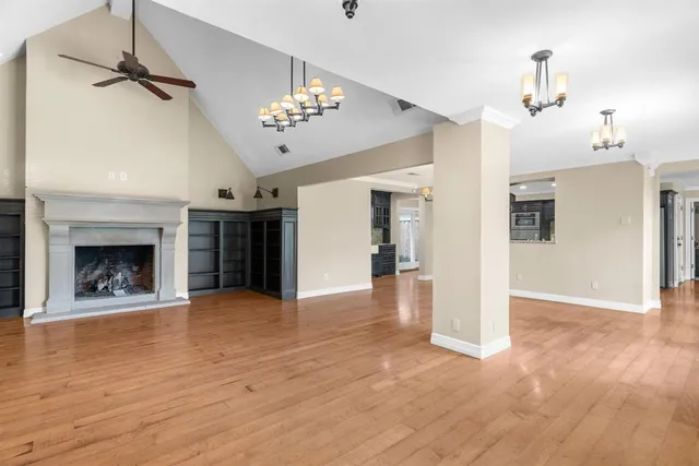 a view of a livingroom with a fireplace a chandelier and wooden floor