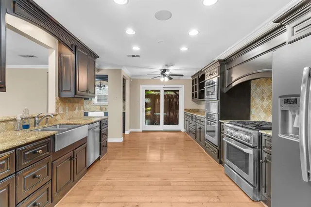 a large kitchen with stainless steel appliances granite countertop a large stove top oven and sink