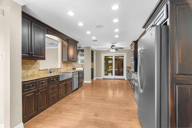a large kitchen with stainless steel appliances granite countertop a refrigerator and a stove top oven