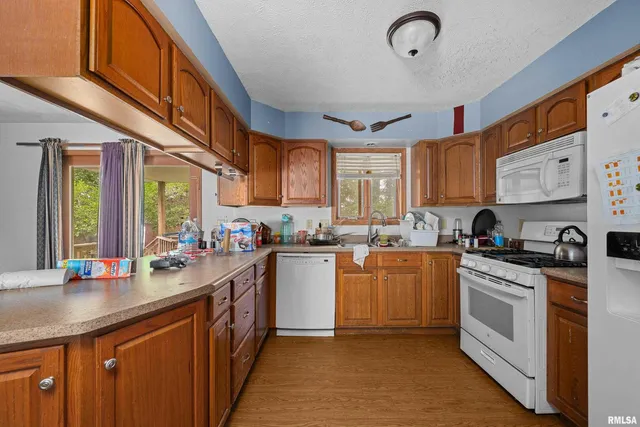 a kitchen with stainless steel appliances granite countertop a stove a sink dishwasher and cabinets with wooden floor