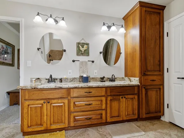 a bathroom with a granite countertop double vanity sink and a mirror
