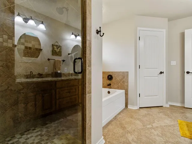 a bathroom with a tub a sink and a mirror
