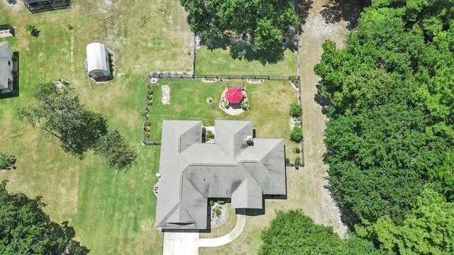 an aerial view of residential house with outdoor space and trees all around