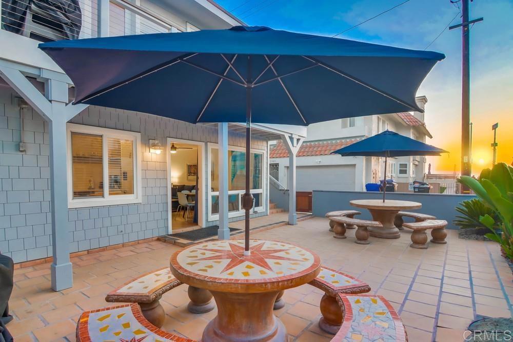 a patio with a table and chairs under an umbrella