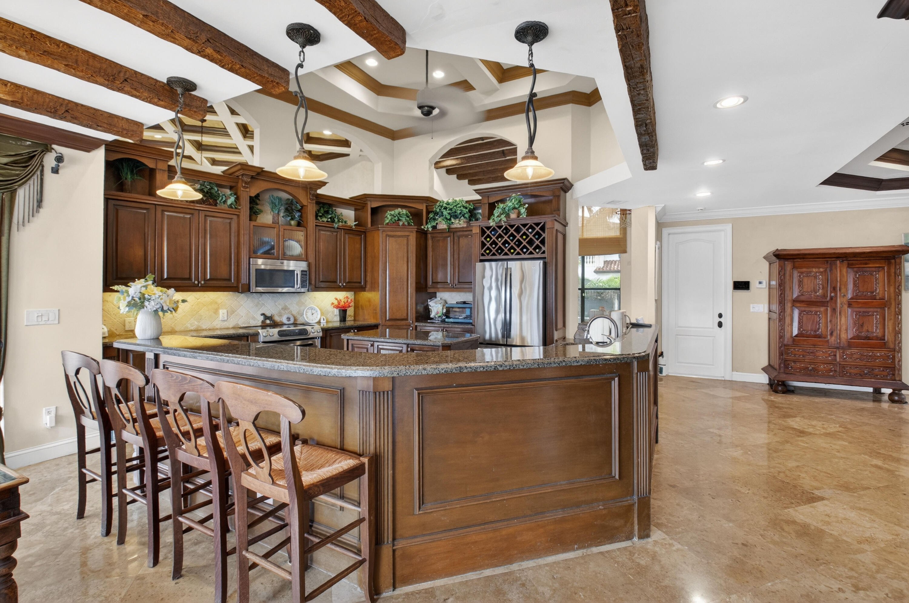 1940 Southwest 7th Place Boca Raton, FL 33486 - Photo 11 of 49 a kitchen with stainless steel appliances granite countertop a table chairs and a chandelier