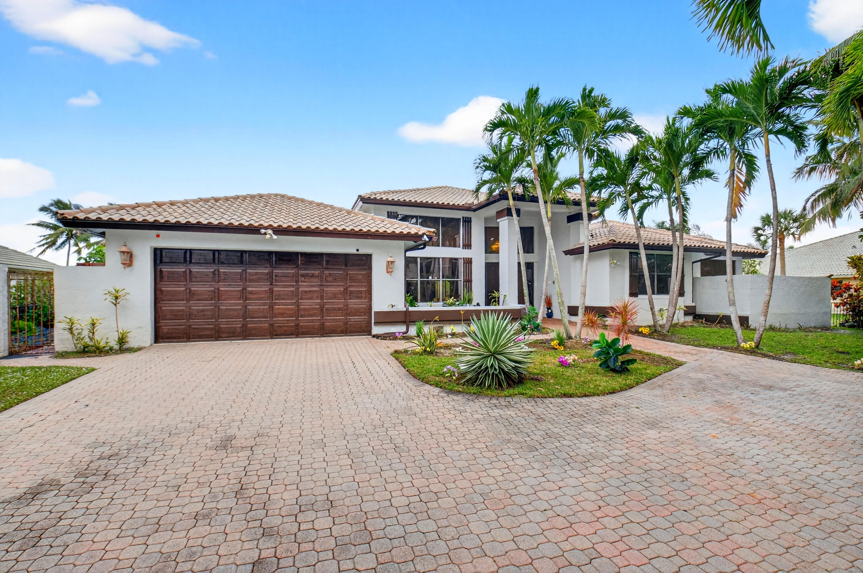 1940 Southwest 7th Place Boca Raton, FL 33486 - Photo 2 of 49 a front view of a house with a garden and plants