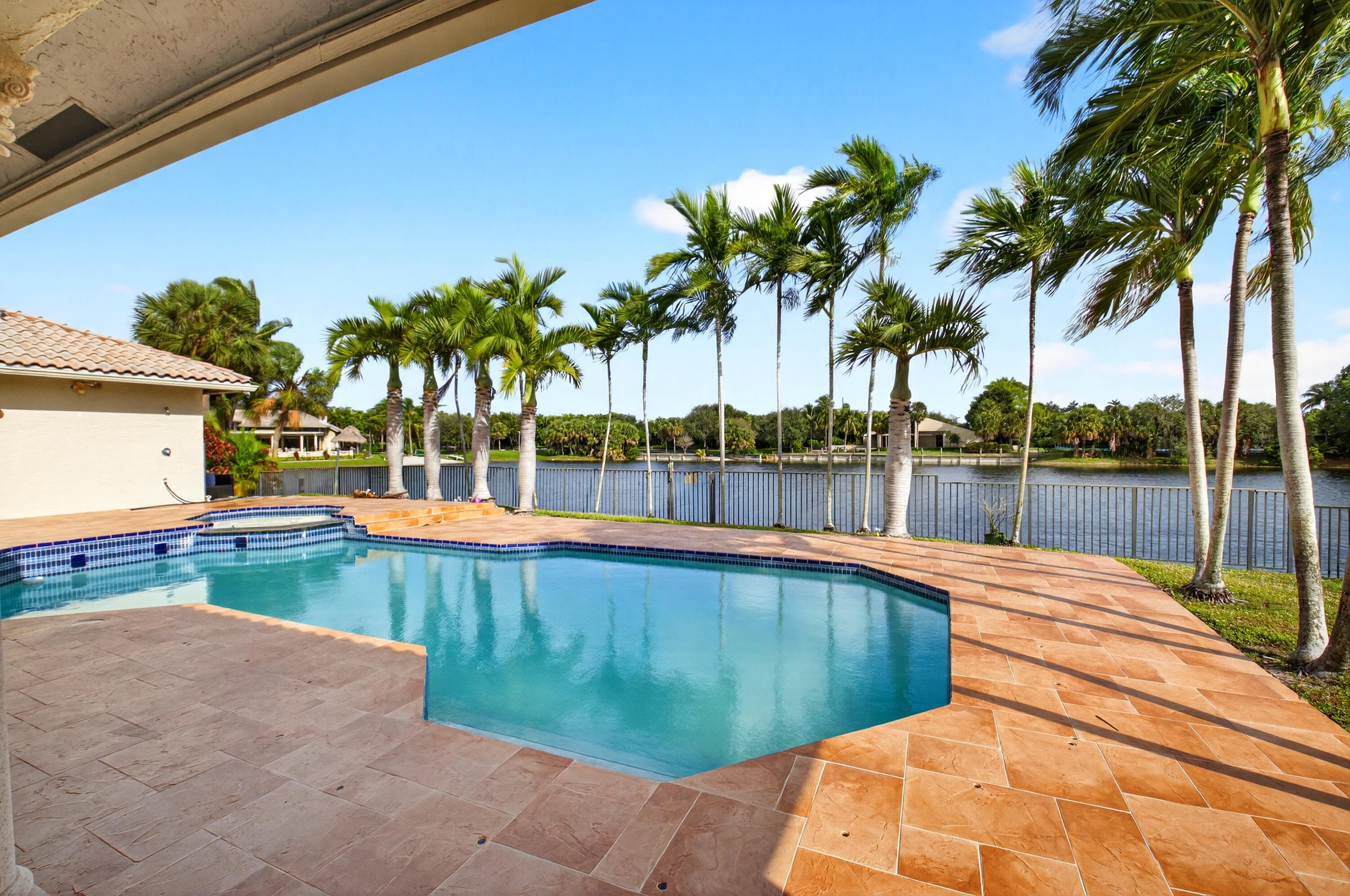 1940 Southwest 7th Place Boca Raton, FL 33486 - Photo 28 of 49 a view of a swimming pool with a lawn chairs and palm tree