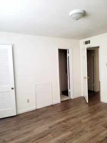 a view of an empty room with wooden floor