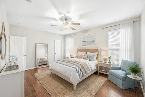 a bedroom with a large bed couch and windows